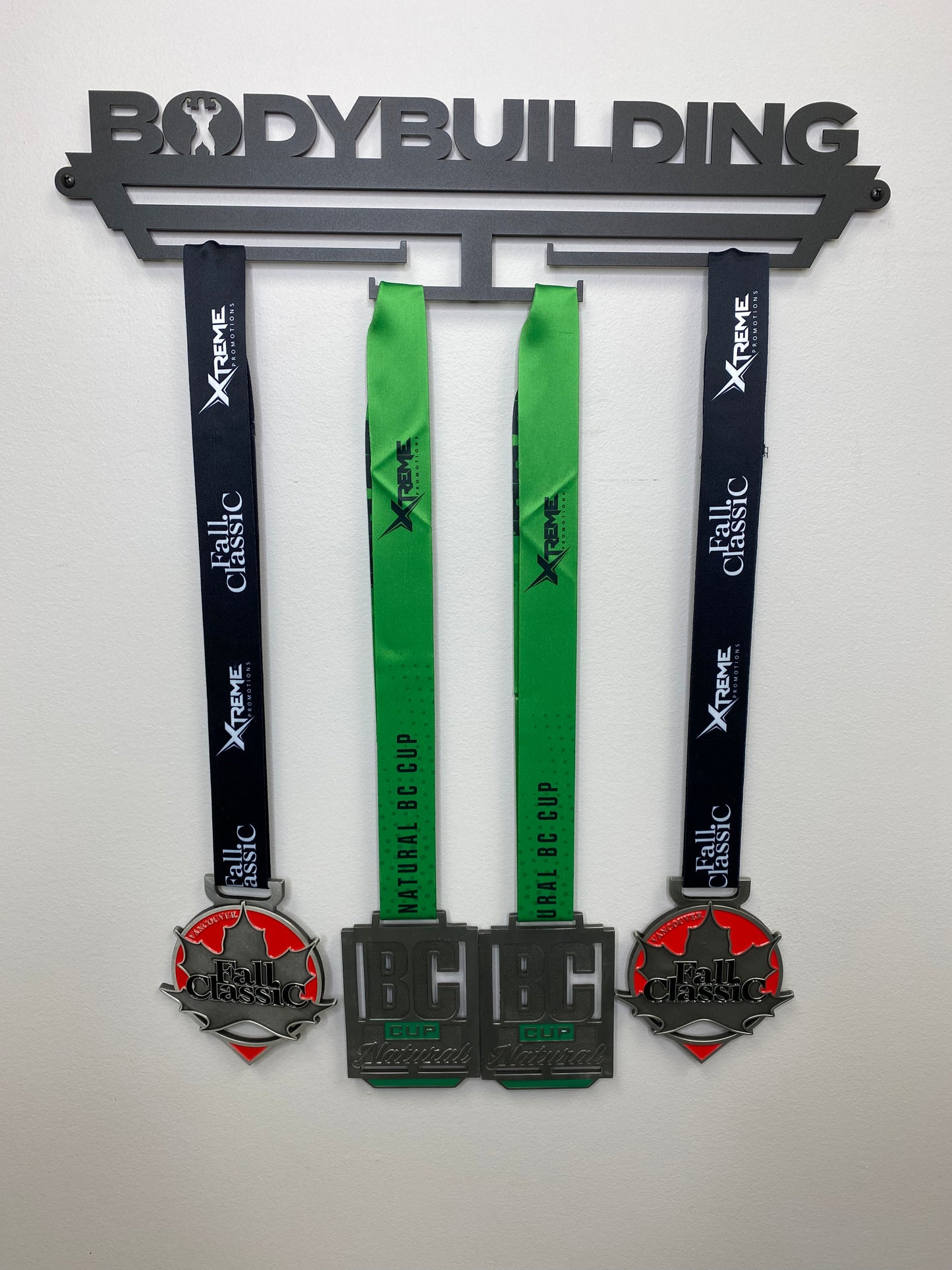 medal hanger for medallions, it reads Bodybuilding across the top with a Bodybuilder posing in the O. and has 4 bars that you can hang the lanyards off of that will display the medals. You will mount this to a wall with the screw kit provided. Comes in black and silver