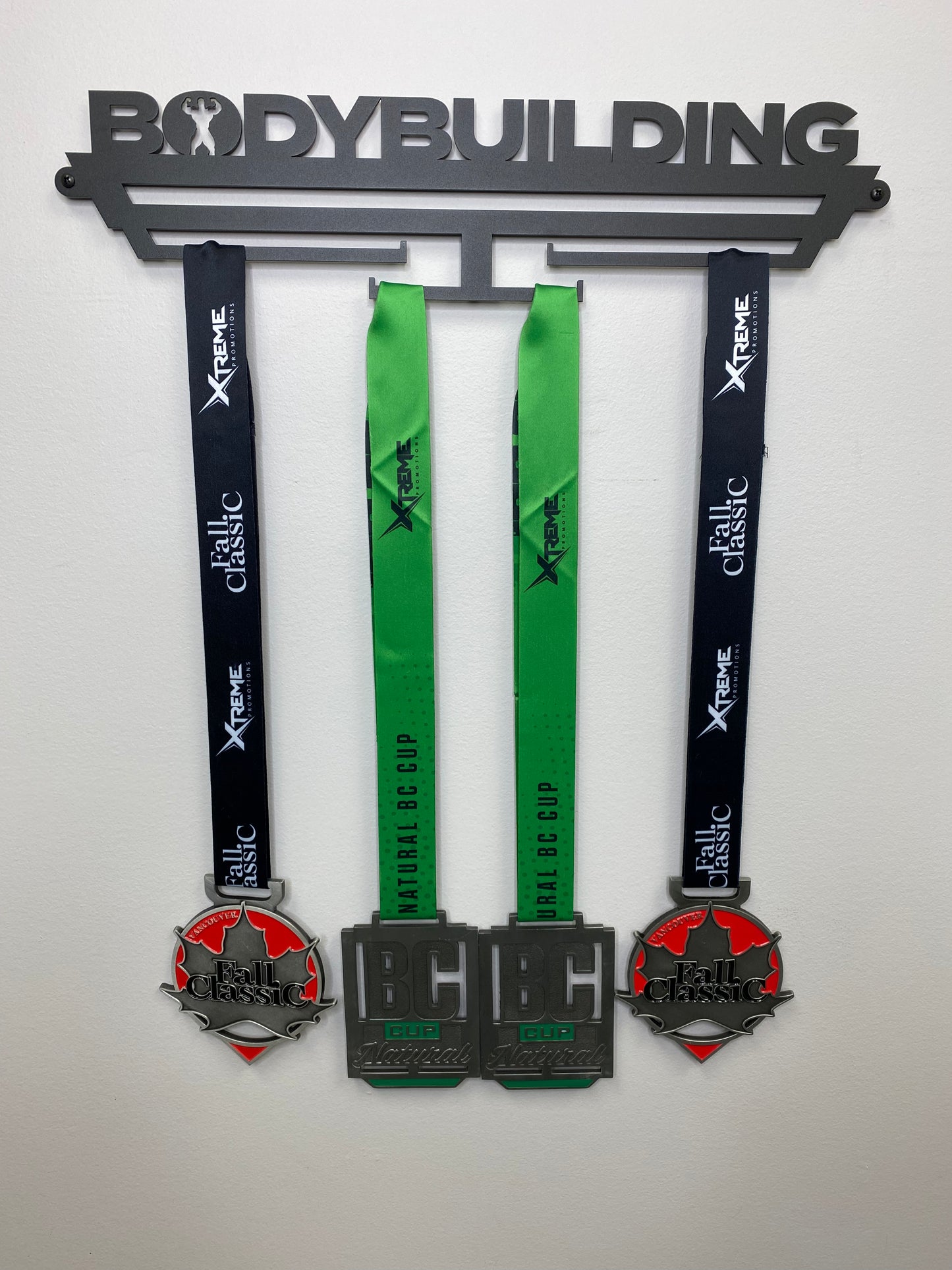 medal hanger for medallions, it reads Bodybuilding across the top with a Bodybuilder posing in the O. and has 4 bars that you can hang the lanyards off of that will display the medals. You will mount this to a wall with the screw kit provided.  Comes in black and silver